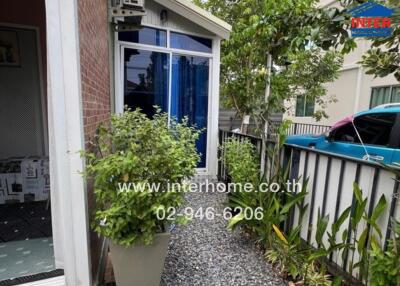 View of a home entrance with lush greenery and attractive landscaping