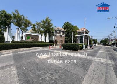 Elegant gated community entrance with security booth and lush greenery