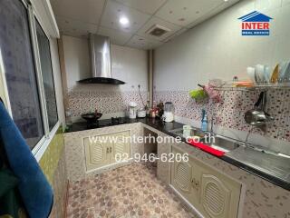 Compact and fully equipped modern kitchen with decorative tiles and stainless steel appliances