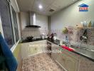 Compact and fully equipped modern kitchen with decorative tiles and stainless steel appliances