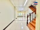 Spacious entry hallway with staircase and bright lighting