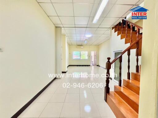 Spacious entry hallway with staircase and bright lighting