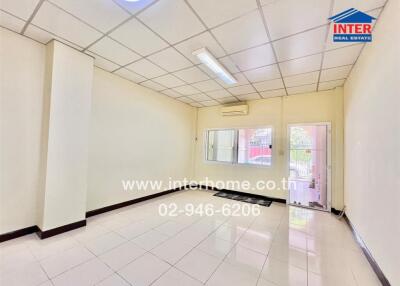Spacious and brightly lit empty room with large windows and white walls