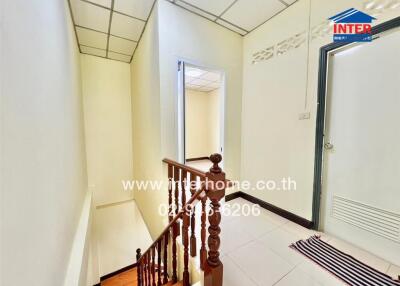 Bright hallway with wooden staircase and decorative ceiling