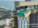 Aerial view of a high-rise building with a rooftop pool overlooking the sea