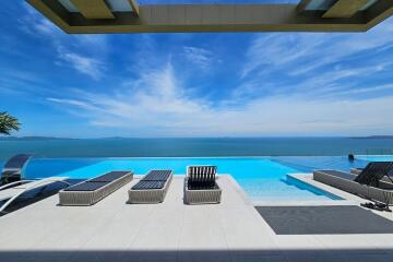 Luxurious infinity pool overlooking the ocean with sun loungers
