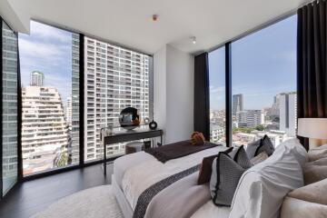 Modern bedroom with large windows offering a city view