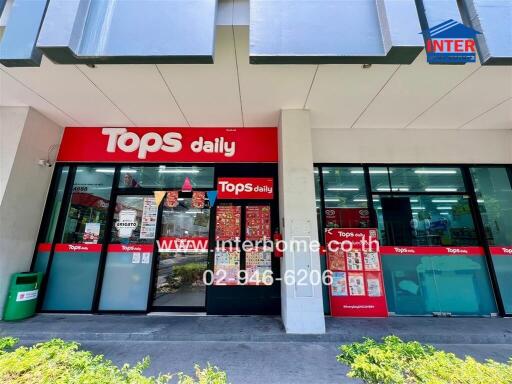 Storefront of Tops Daily supermarket with red signage