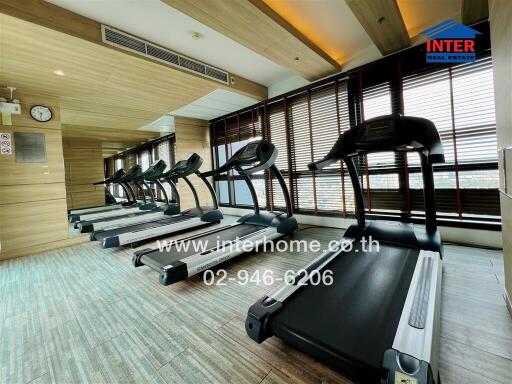 Well-equipped indoor gym with multiple treadmills and wooden accents