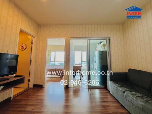 Spacious living room with wooden flooring and balcony access