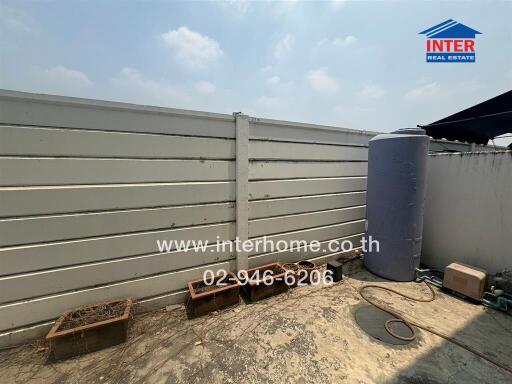 Outdoor side space with water tanks and empty planters