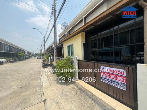 Exterior view of a residential building with a for sale sign