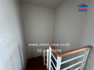 Small bedroom space with open door and wooden railing