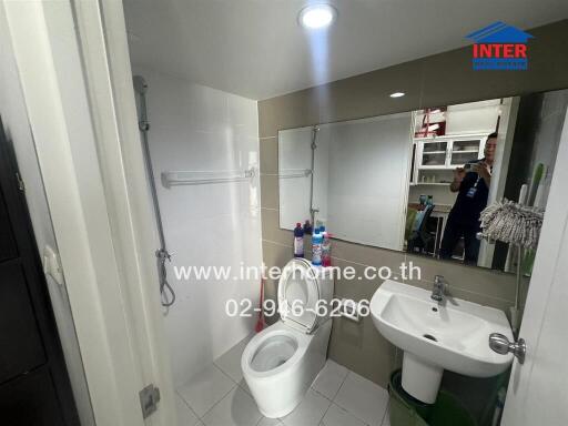 Modern bathroom with large mirror and white fixtures