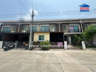 Exterior view of modern townhouses with balconies and parking spaces