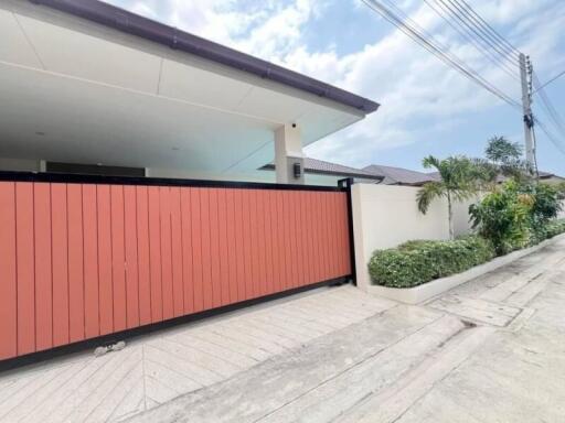Modern home exterior with large red gate and spacious driveway