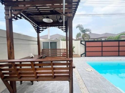 Spacious outdoor area with swimming pool and wooden gazebo