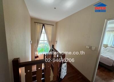 Bright staircase area leading to upper floor with a view into a cozy bedroom