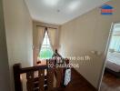 Bright staircase area leading to upper floor with a view into a cozy bedroom