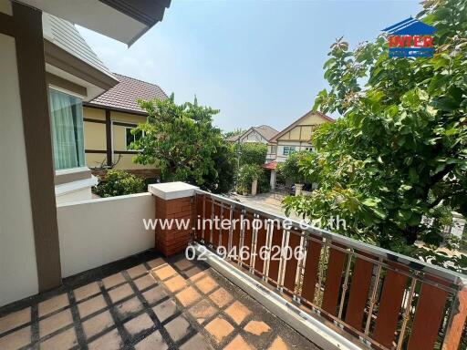 Spacious balcony overlooking the neighborhood with lush greenery