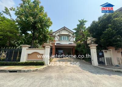 Exterior view of a spacious two-story house with a large gated entrance