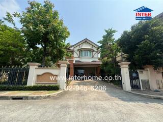 Exterior view of a spacious two-story house with a large gated entrance