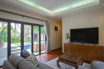 Spacious and modern living room with open sliding doors leading to a garden