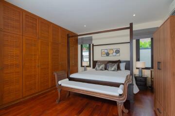 Spacious bedroom with large wooden bed and extensive closet space