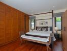 Spacious bedroom with large wooden bed and extensive closet space
