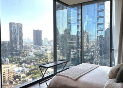 Modern bedroom with large windows overlooking city skyline