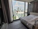 Modern bedroom with large windows offering a city view