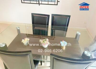 Modern dining area with glass table and black chairs