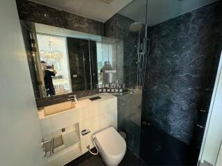 Modern bathroom with elegant dark marble walls and luxurious fixtures