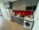 Modern kitchen with integrated appliances and red backsplash