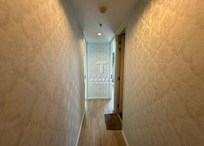 Elegant hallway interior with patterned wallpaper and wood flooring