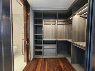 Spacious walk-in closet with custom shelving and wooden flooring