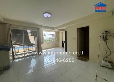 Spacious and well-lit living room with large windows and balcony access