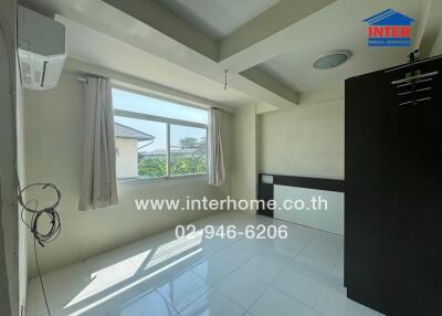 Spacious bedroom with ample natural light and modern air conditioning unit