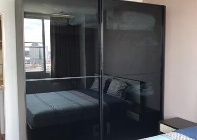 Modern bedroom with large mirrored wardrobe and city view
