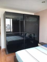 Modern bedroom with large mirrored wardrobe and city view