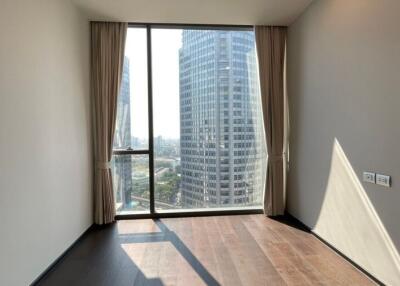 Empty bedroom with large window offering city view