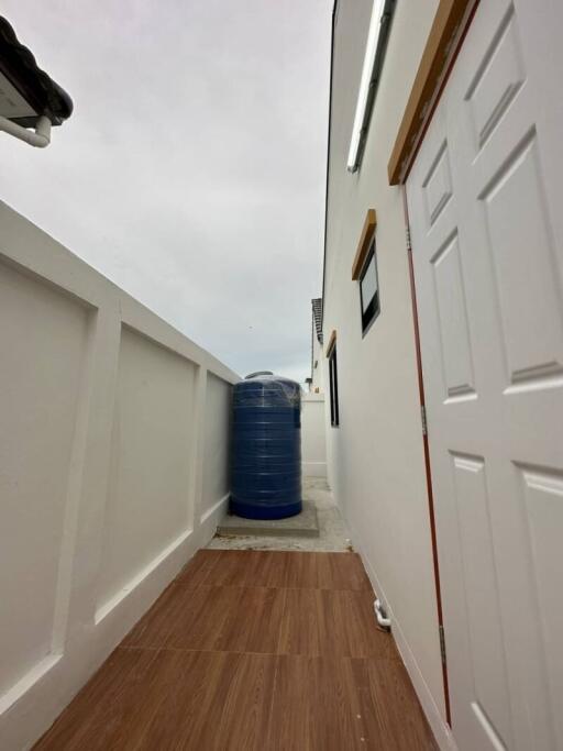 Narrow side alley with a blue water tank and white walls