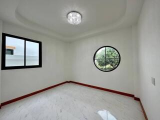 Spacious empty bedroom with circular and rectangular windows