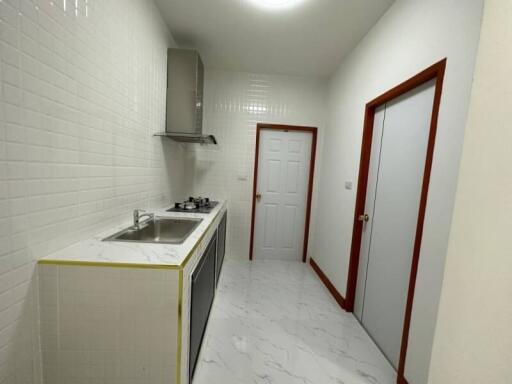 Compact kitchen with white subway tiles and marble flooring