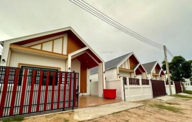 Modern single-family home with white walls and red accents, including a spacious driveway