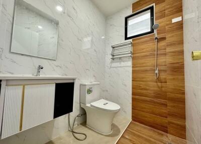 Modern bathroom with marble tiles and wooden accents