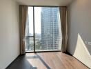 Empty bedroom with large window overlooking city