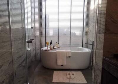 Elegant bathroom with a modern freestanding bathtub, tiled walls, and natural light