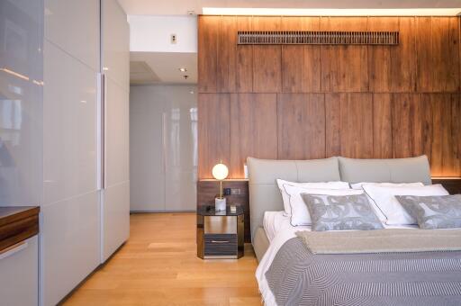 Modern bedroom with wooden wall paneling and ambient lighting