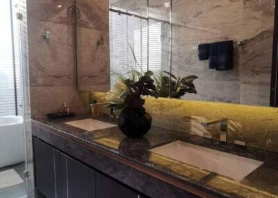 Modern bathroom interior with illuminated yellow marble countertop and double sinks